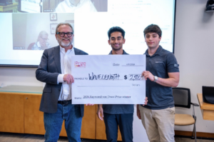 Syracuse University seniors Taran Krishnan (center) and Zach Richter (right) are presented with a check following the latest pitch for the NIL agency Wavelength for SU's LaunchPad.